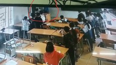 Vị phụ huynh côn đồ (áo xanh) đang tấn công học sinh mặc đồng phục được camera ghi lại. (Ảnh: Giáo dục & Thời đại)