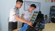 Nguyễn Hữu Thực và Trần Hoàng Nguyên với mô hình máy điều khiển tự động thu gom nông sản. (Ảnh: Nguyễn Thành/TTXVN)