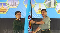 Thiếu tướng Hoàng Kim Phụng nhận cờ đăng cai tổ chức Hội nghị APCN năm 2020 tại Việt Nam. (Ảnh: Hà Ngọc-Hoàng Nhương/Vietnam+)