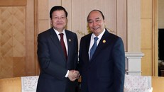 Thủ tướng Nguyễn Xuân Phúc gặp Thủ tướng Lào Thongloun Sisoulith tại Busan, Hàn Quốc. (Ảnh: Thống Nhất/TTXVN)