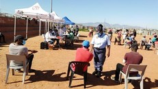 Cảnh sát nhắc nhở người dân thực hiện giãn cách xã hội trong khi chờ đợi đến lượt tại một điểm xét nghiệm COVID-19. (Ảnh: Phi Hùng/TTXVN)