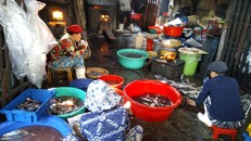 Những người thợ hấp cá ăn vội buổi sáng ngay tại lò hấp. Ảnh: Vân Phi