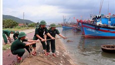 Lực lượng Đồn biên phòng Cửa Sót (Hà Tĩnh) giúp ngư dân giằng néo tàu thuyền phòng chống bão số 4. Ảnh: Công Tường/TTXVN