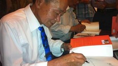 Nhà thơ Du Tử Lê ký tặng độc giả trong buổi ra mắt "Giỏ hoa thời mới lớn" tại Hà Nội năm 2014. (Ảnh: PV/Vietnam+)