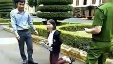 Bà Hoa Anh quỳ trước UBND tỉnh xin nộp đơn tiếp công dân. Ảnh: Cắt từ clip.