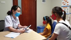 Tiến sỹ Nguyễn Ngọc Khánh khám cho một bé gái dậy thì sớm. (Ảnh: T.G/Vietnam+)