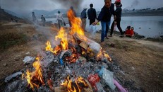 Người dân đốt túi nylon sau khi thả cá trên bờ sông Đà nhằm hạn chế ô nhiễm rác thải nhựa. 