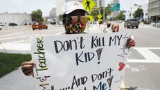 Một giáo viên biểu tình cùng các đồng nghiệp trước văn phòng học khu hạt Hillsborough, thành phố Tampa, Florida, hôm 16/7, với biểu ngữ "Đừng giết con tôi và đừng giết tôi!". Ảnh: AFP