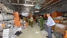 Lực lượng chức năng kiểm tra kho hàng chứa hàng giả. Ảnh: QL/TTXVN