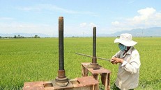 Ông Cấm xả van ở mương thủy lơi để dẫn nước vào đầy các thửa ruộng, ngày 12/8. Ảnh: Đức Huynh