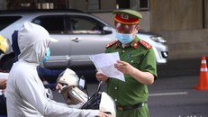 Cảnh sát kiểm tra giấy đi đường của người dân. (Ảnh: Danh Trọng)