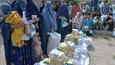 Người dân nhận lương thực cứu trợ tại Jalalabad, Afghanistan, ngày 20/4/2021. Ảnh: AFP/TTXVN