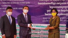 Quốc vụ khanh Bộ Y tế Campuchia Or Vandine (phải) bàn giao số vaccine cho Thứ trưởng Bộ Y tế Trần Văn Thuấn. 