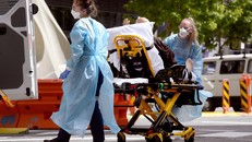 Nhân viên y tế chuyển bệnh nhân COVID-19 tới bệnh viện tại Melbourne, Australia. (Ảnh: AFP/TTXVN)