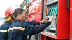 Thượng tá Đỗ Anh Quyến (phải) kiểm tra thiết bị trên xe cứu hỏa. (Ảnh: T.H/Vietnam+)