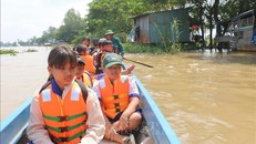 Anh Trần Văn Hiền, chiến sĩ Dân quân tự vệ xã Vĩnh Hội Đông lái vỏ lãi (xuồng composite) đưa các em học sinh về tận nhà. (Ảnh: TTXVN)