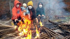 Người dân đốt lửa sưởi ấm trong tiết trời lạnh giá. (Ảnh: Hoàng Hùng/TTXVN)