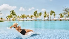 Khách hàng tận hưởng cảm giác thư thái bên bể bơi tuyệt đẹp trong khu nghỉ dưỡng Mövenpick Resort Waverly Phú Quốc