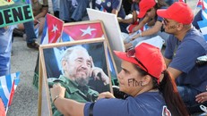 Người dân Cuba cầm theo di ảnh của Fidel Castro và viết tên ông lên mặt