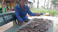 Anh Hòa đang giữ ba bộ hài cốt vừa tìm thấy. Ảnh: Ái Loan