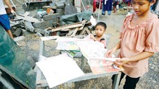 Con anh chị Hoà, Sâm công nhân Formosa đang phơi sách vở do bị bão làm ướt. Ảnh: Hồng Vĩnh