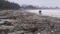 Người dân địa phương "lội" giữa bãi rác để đi dạo ven bãi biển