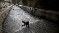 Mỗi ngày, dòng sông Guaire đều xuất hiện những người mò rác đê rkieems tiền sống qua ngày. (Nguồn: AP)