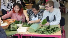 Chị Thanh Vân (giữa) cùng các bạn ngoại quốc làm bánh chưng