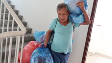 Ông Trần Quang Huệ mang hành lý ra khỏi chung cư
