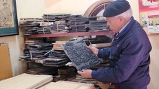 Nghệ nhân Nguyễn Đăng Chế giới thiệu bản khắc cổ của dòng tranh dân gian Đông Hồ. (Ảnh: TTXVN)