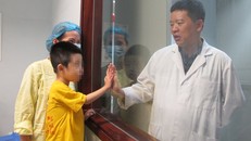 Bé Dũng chơi đùa với bác sĩ trước giờ xuất viện