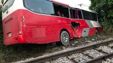 Tàu hoả tông ô tô chở học sinh móp ngang hông khiến một số em bị thương nhẹ và hoảng hốt.