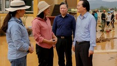 Giáo viên trường Tiểu học Hàm Ninh báo cáo Bộ trưởng Phùng Xuân Nhạ về tình hình lũ lụt và những thiệt hại mà nhà trường phải gánh chịu trong đợt lũ lịch sử vừa qua. Ảnh: Thế Đại