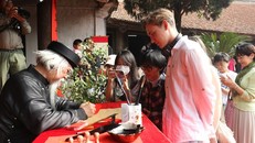Khách quốc tế cũng hào hứng với không gian trải nghiệm văn hóa Tết cổ truyền ông Đồ cho chữ. Ảnh: VGP