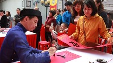 Người dân xin chữ tại buổi lễ. Ảnh: TTXVN