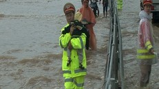 Cảnh sát giao thông bế trẻ qua đoạn nước lụt