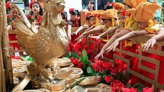 Các học sinh Philippines gốc Hoa đội mũ gà trống và ném đồng xu vào nơi đặt tượng gà màu vàng để cầu may mắn, thịnh vượng tại trung tâm mua sắm Lucky Chinatown, thành phố Binondo, Philippines. 