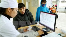 Nhân viên y tế làm thủ tục khám chữa bệnh cho người dân. (Ảnh: TTXVN/Vietnam+)