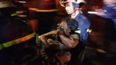 Nữ chủ nhà được cảnh sát đưa ra ngoài.