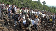 Các binh sĩ đưa thi thể những nạn nhân trong chiếc xe chở khách bị chôn vùi ra ngoài. Ảnh: AP.