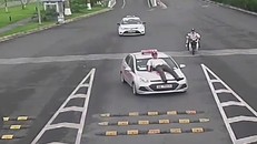 Nhân viên bảo vệ nằm trên nắp capo của xe taxi. Ảnh cắt từ clip.