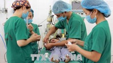 Các bác sĩ tiến hành phẫu thuật cho trẻ khuyết tật. Ảnh: TTXVN