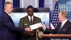 Thư ký báo chí Nhà Trắng Sean Spicer trao tấm séc cho Bộ trưởng Nội vụ Ryan Zinke . Ảnh: Getty.