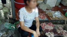 Chị Xuyến cùng khoảng 50kg thịt lợn bị hắt dầu luyn trộn với chất thải. Ảnh cắt từ video.