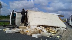 Chiếc xe lật nhào chắn ngang đường. Ảnh: CAND