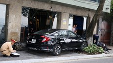 Chiếc ô tô mất lái lao lên vỉa hè. Ảnh: Thanh Niên