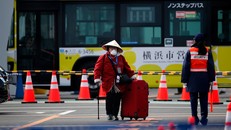 Một nữ hành khách rời tàu Diamond Princess sau thời hạn 14 ngày cách ly. Ảnh: AP