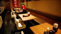 Một nữ nhân viên đang dọn bàn tại một nhà hàng ở Tokyo vào ngày 8/5. Ảnh: Reuters