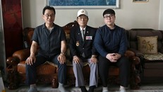 Yang Tae-sung (giữa) cùng con trai Yang Kyung-mo (trái) và cháu trai Yang Hee-kon (phải) tại nhà riêng ở Seoul. Ảnh: AFP