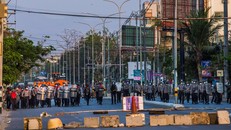 Lực lượng an ninh ở Mandalay chuẩn bị bước qua rào chắn do người biểu tình dựng lên. Ảnh: NY Times